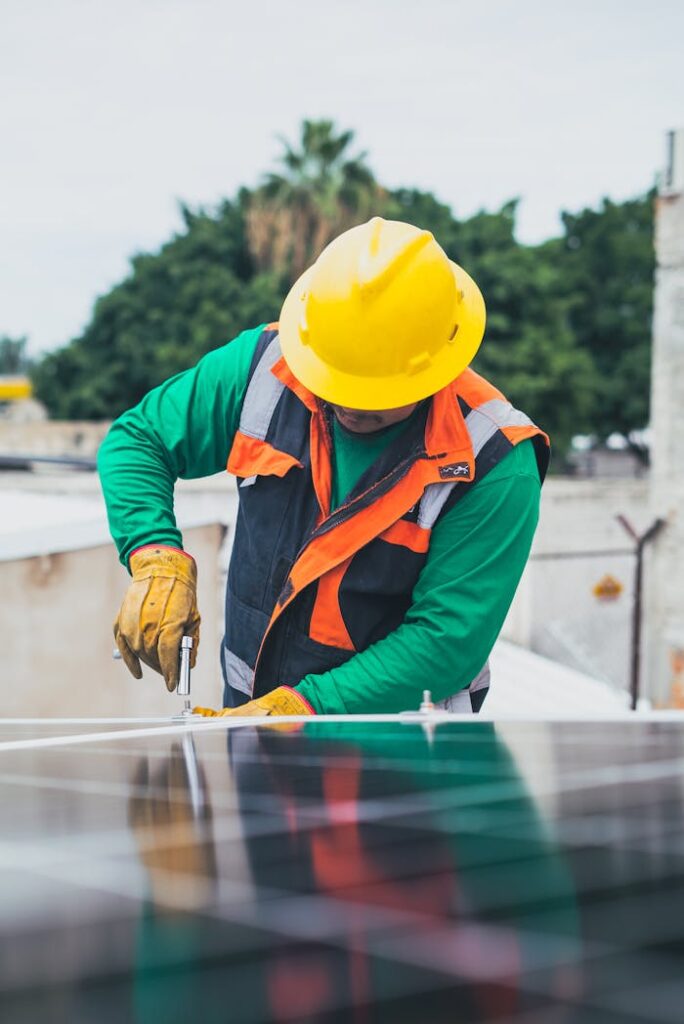 pexels-photo-8853506 Professional solar panel technician working outdoors with PPE.